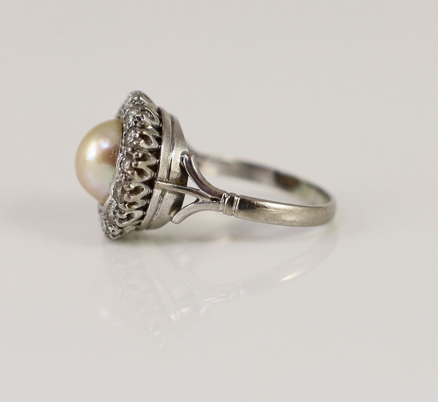 A mid 20th century platinum?, split pearl and diamond set circular cluster ring